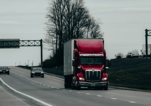 red and white truck on road during daytime